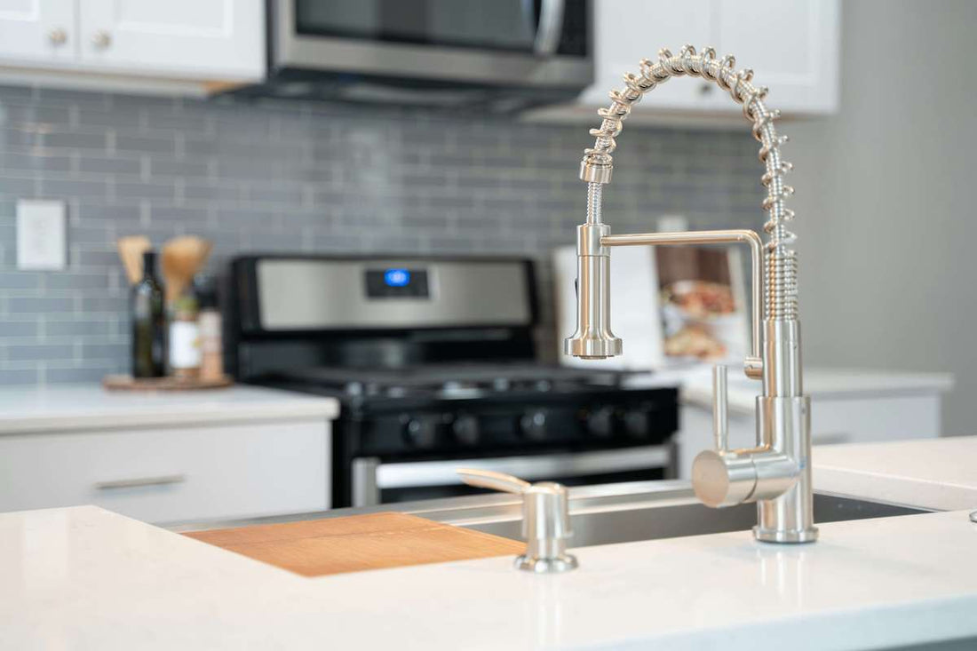 Stainless steel pull-down kitchen faucet with sprayer in a modern kitchen, showcasing its flexible hose and ease of use for rinsing dishes, as highlighted in the Benefits of a Kitchen Faucet with Sprayer blog.