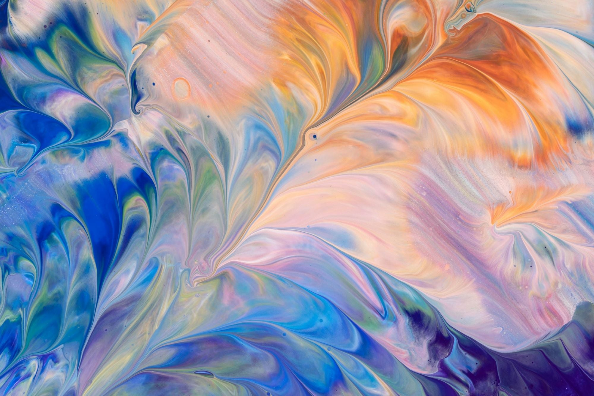 A fluid abstract painting with swirling patterns of blue, orange, purple, and green. The colors blend seamlessly, creating a marbled effect with soft, flowing textures. The composition has a dynamic, wave-like movement with areas of light and dark contrast.