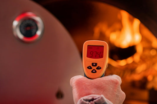 Infrared Thermometer pointing at pizza oven, measuring temperature.